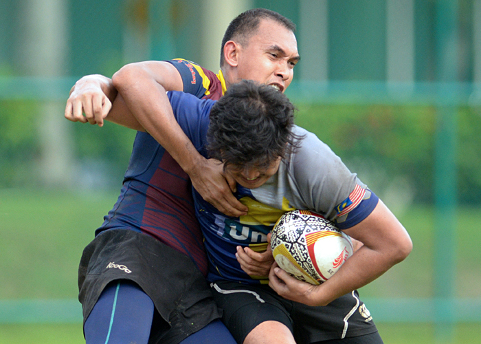 Ketua Pasukan Kajang Rams RC; Muhammad Shahrulnizam Abu Seman(kiri) cuba melakukan tumbang sisi ke atas lawannya dari MIAT Falcons(kanan) semasa perlawanan akhir Cup di Kejohanan Ragbi Liga Putrajaya yang telah berlangsung dipadang Alamanda, Putrajaya. Foto - Sukandaily
