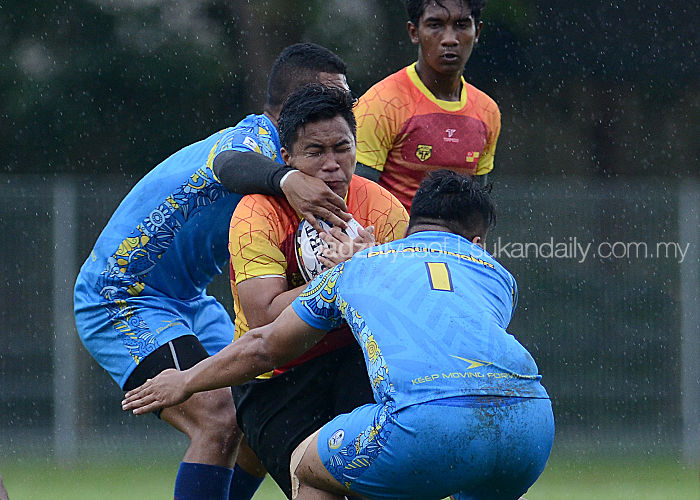 Pemain Selangor(tengah) dikekang oleh dua pemain pasukan Pulau Pinang dalam perlawanan pembukaan Divisyen 2 Kejohanan Ragbi Piala Agong 2018 Ke-36 yang berlangsung di Padang Utara, Petaling Jaya. Kredit Foto – Sukandaily